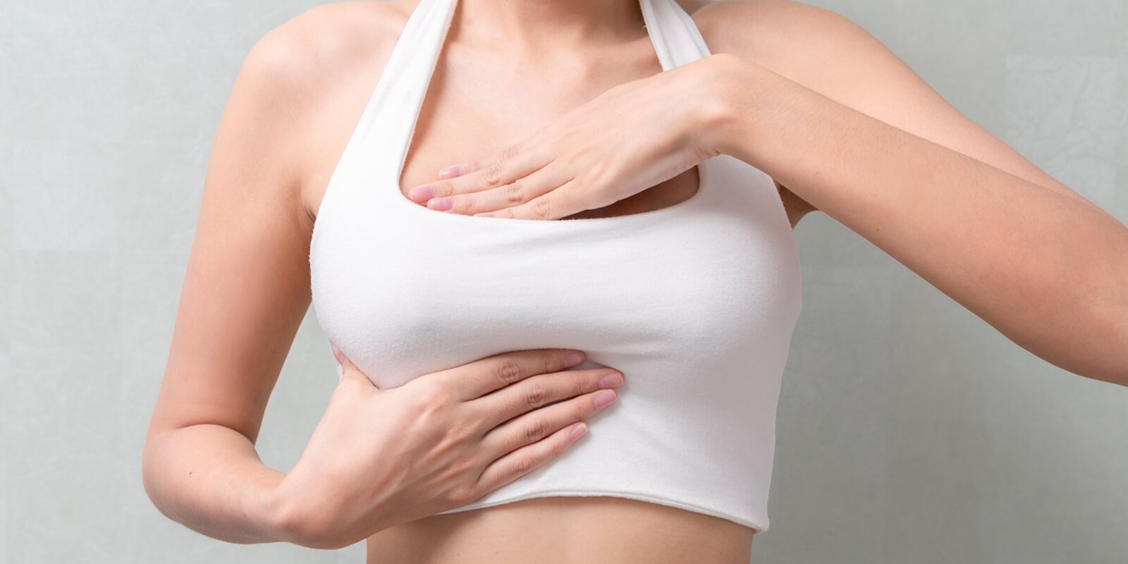 Raleigh, NC woman hand checking lumps on her breast cancer for signs of breast cancer on background