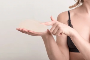 young woman touch her breast implant before surgery