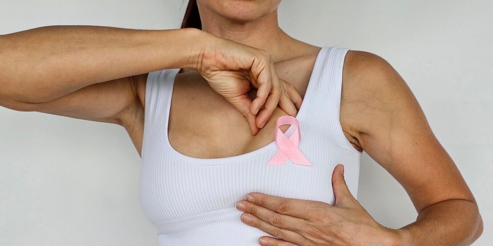 woman with pink ribbon on her chest to promote breast cancer awareness to get mammography