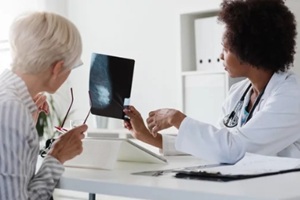 aged women checking mammogram result with a doctor
