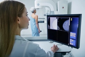 medical technician taking mammogram exam to female patient