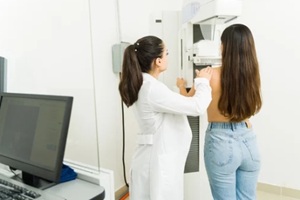 rear view of a doctor helping a patient getting a mammography exam