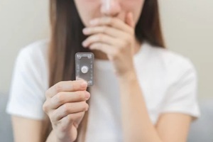 asian young woman hand holding birth control pills