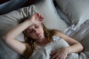 menopausal mature woman suffering with insomnia in bed in Raleigh, NC home