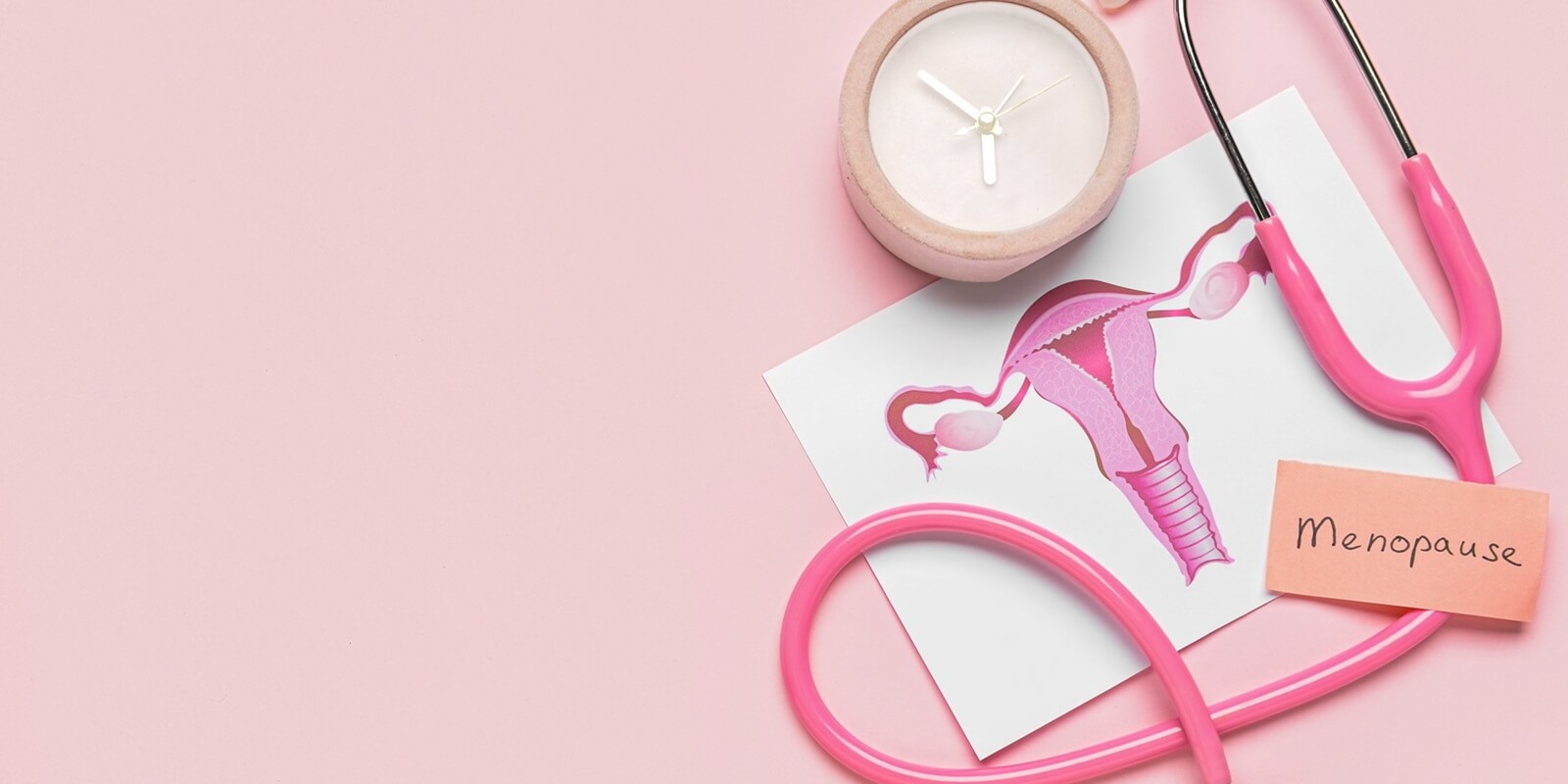 papers with word MENOPAUSE, uterus, stethoscope and alarm clock on pink background