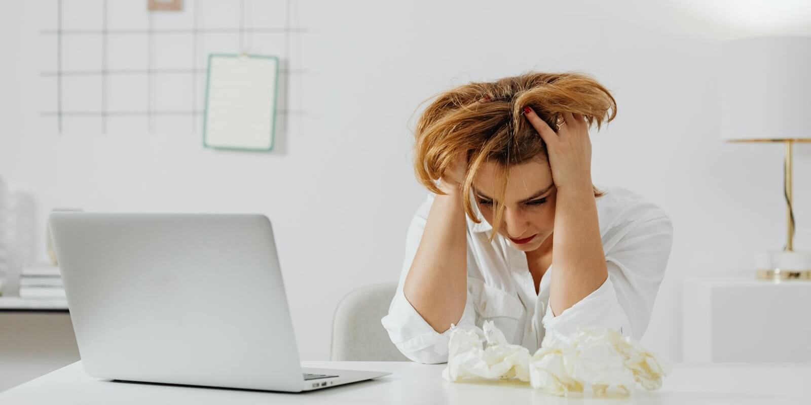 a woman in white long sleeves looking stressed