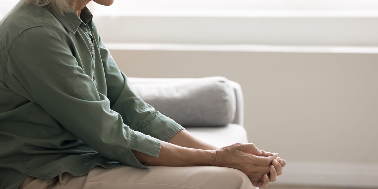 shot weak vulnerable elderly woman sit on sofa bent down at home in hospital deal with depression
