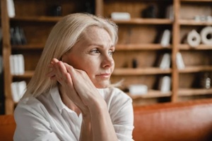 stressed sad tired exhausted caucasian middle-aged mature businesswoman freelancer relaxing on the couch sofa