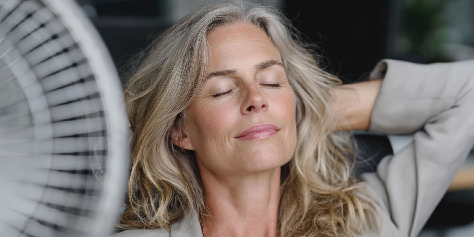 mature businesswoman experiencing menopause symptoms at work