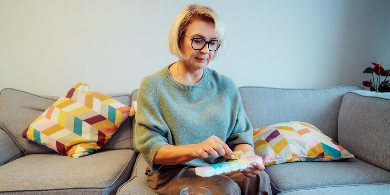middle age female holds pill box in her hands - menopause specialist