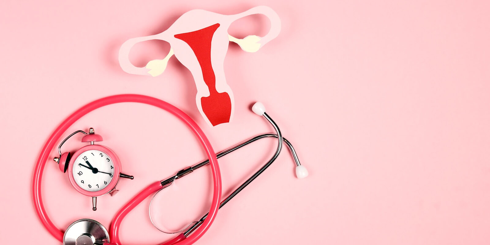 uterus symbol with stethoscope and alarm clock on pink background - menopause specialist