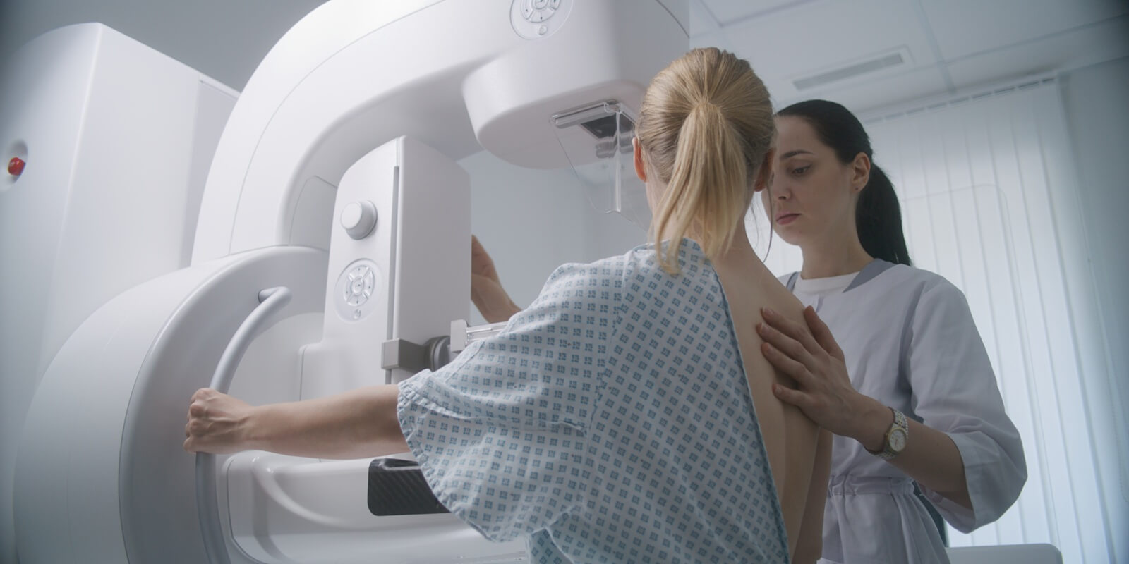 aucasian woman stands during mammography screening examination in clinic