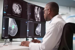 doctor monitors african american man's breast tumor diagnosis before