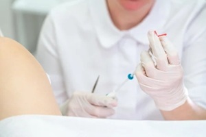 gynecologist holding an IUD birth control device before using it for patient