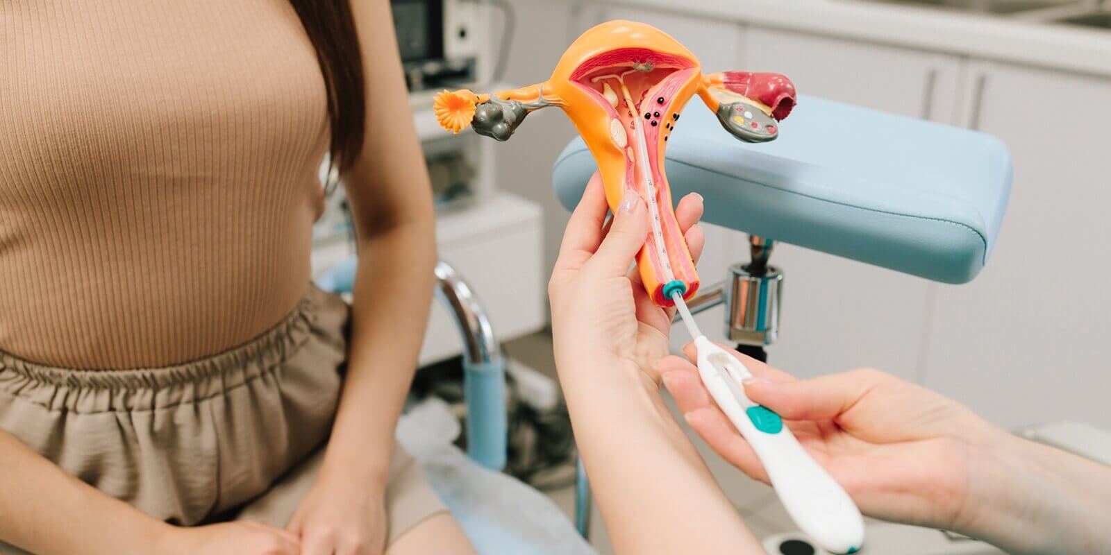 gynecologist demonstrates intrauterine device IUD insertion using uterus model