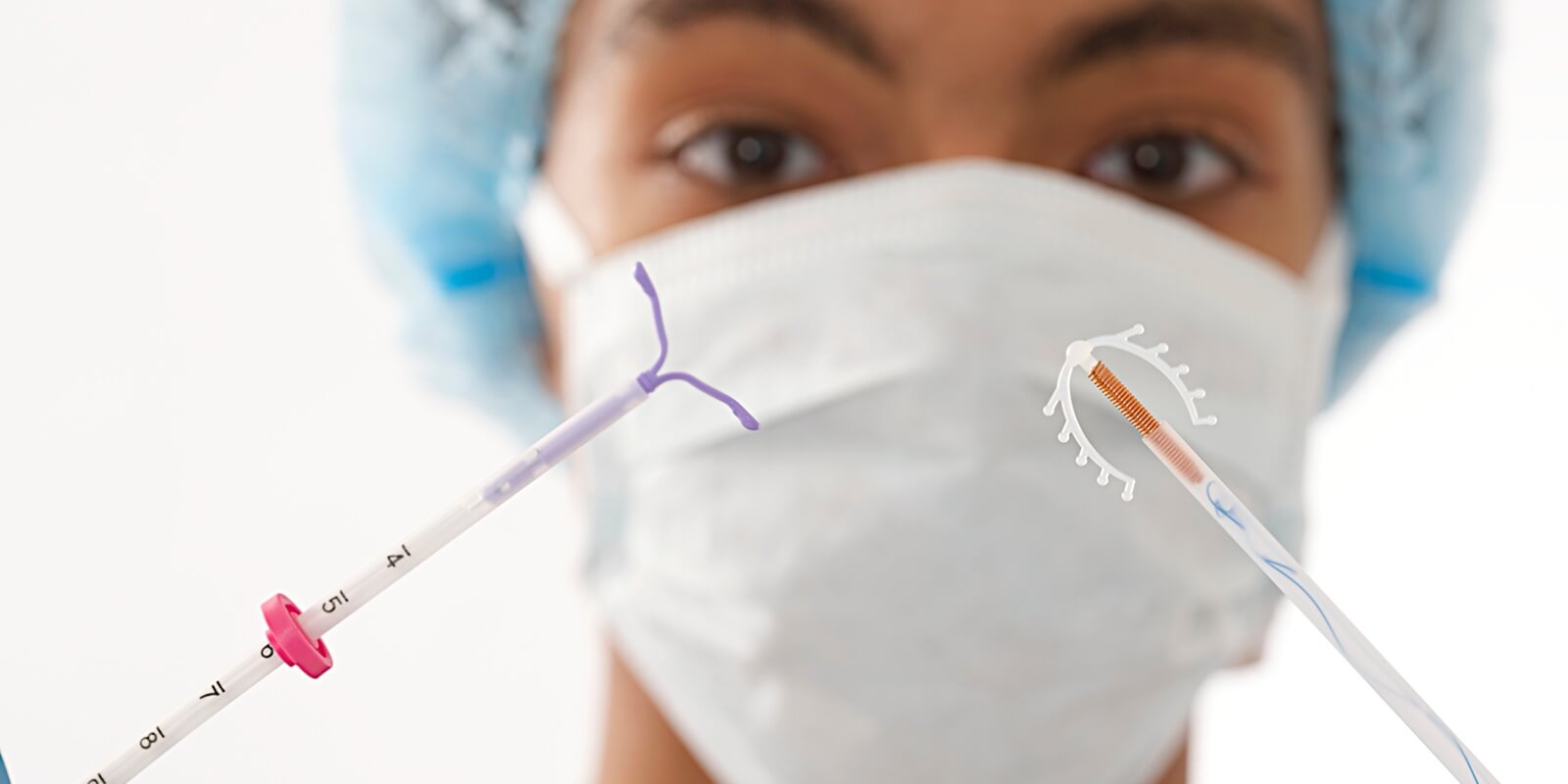 young doctor holding two type of IUD birth control