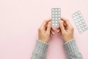contraceptive pills in hand held by female