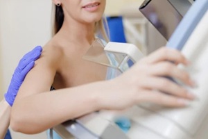 woman receiving mammogram screening during clinic visit, white light