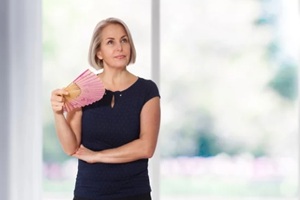 attractive middle aged woman relaxing with fan
