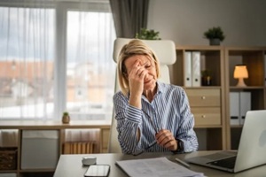 mature woman have headache at office