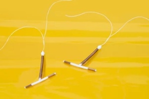two intrauterine coils on yellow background
